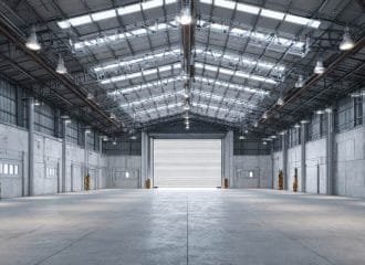 Galpão industrial amplo com estrutura metálica, pé-direito alto e iluminação natural para operações logísticas e armazenamento